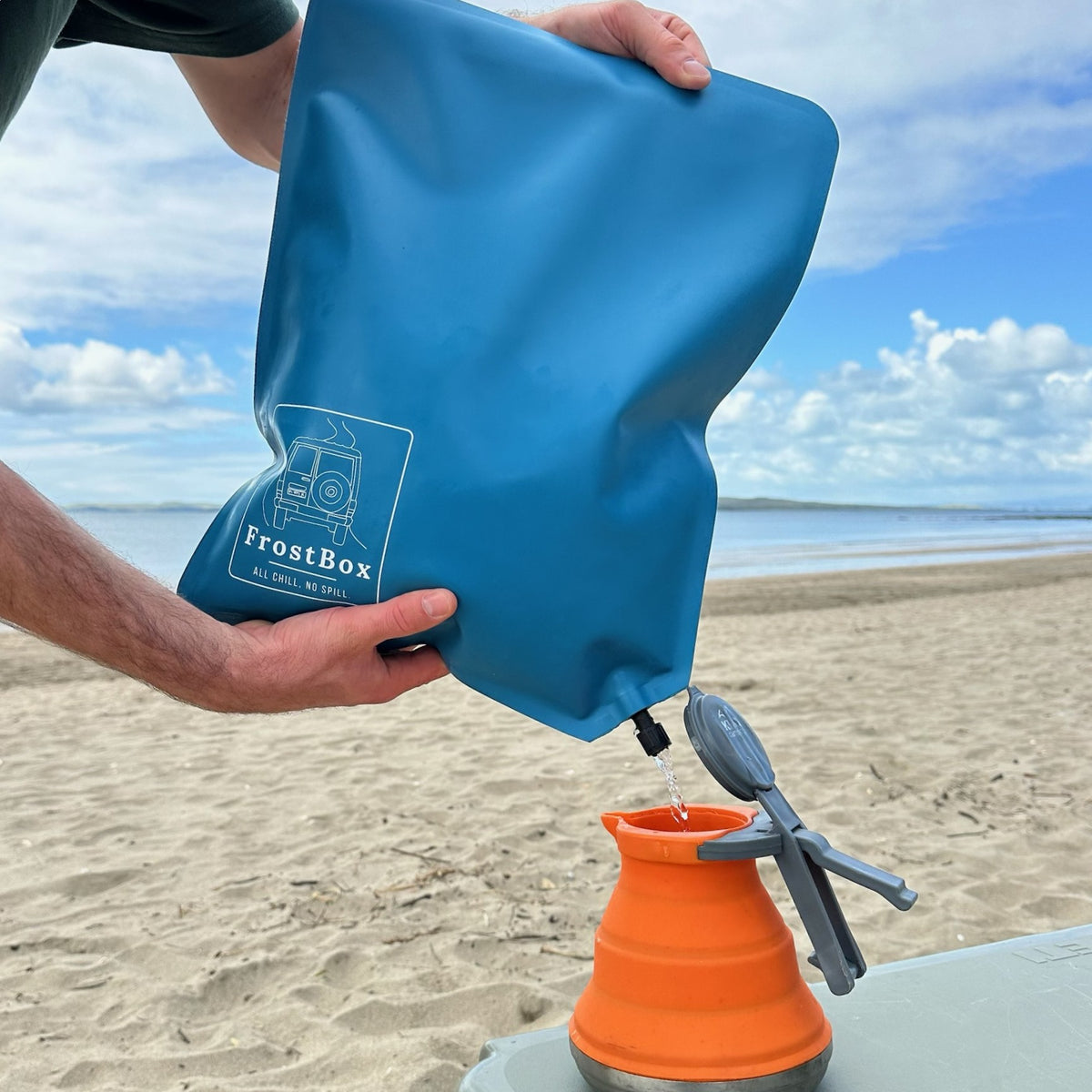 Draining meltwater from a Tasman Blue FrostBox through the drain cap at the beach